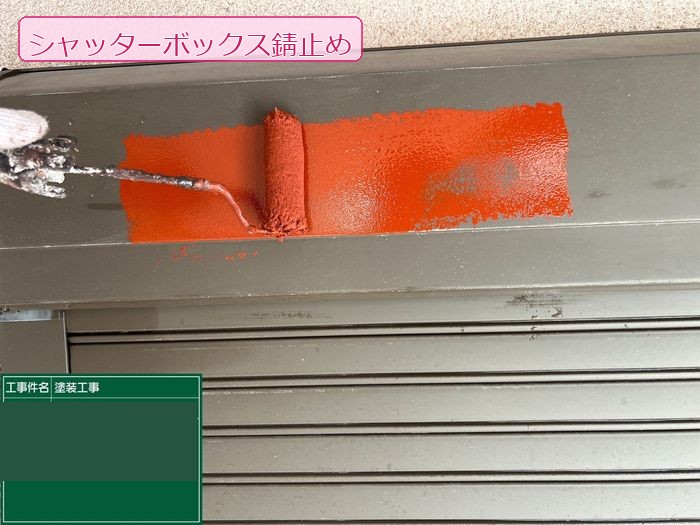 八尾市久宝寺のY様邸 シャッターボックスに赤色の錆止め塗料をローラーで塗布している作業の様子