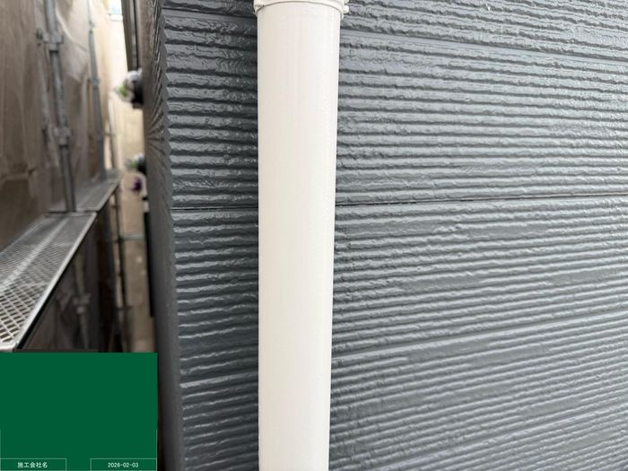 八尾市曙川東 縦樋の上塗り完了（白色）と背景のネイビー外壁