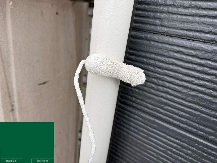 八尾市曙川東のT様邸 竪樋（縦の雨樋）を小型ローラーで下塗り塗装している様子