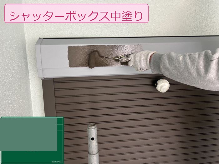 八尾市久宝寺のM様邸 シャッターボックスにローラーで中塗り塗料を塗布している様子