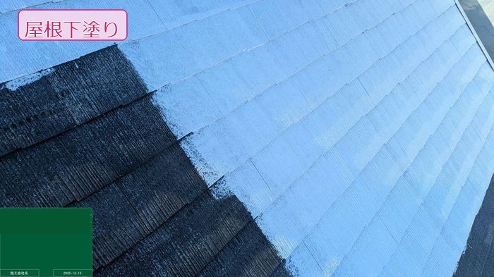松原市別所のT様邸 スレート屋根の下塗り施工中 左半面が未塗布・右半面に灰青色のシーラーを塗り広げている様子