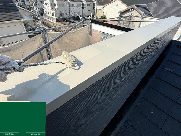 八尾市曙川東 笠木（パラペット上部）の上塗り施工中（ローラー使用）