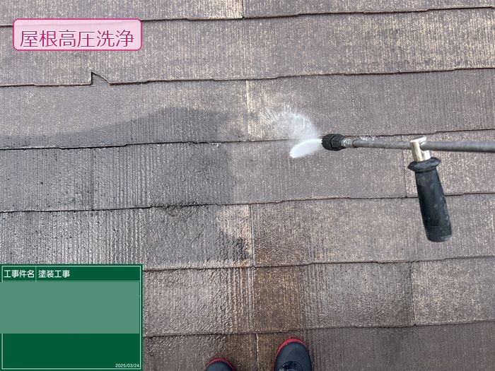 八尾市久宝寺のI様邸 スレート屋根の上で高圧洗浄機を使って苔を除去している作業中の様子