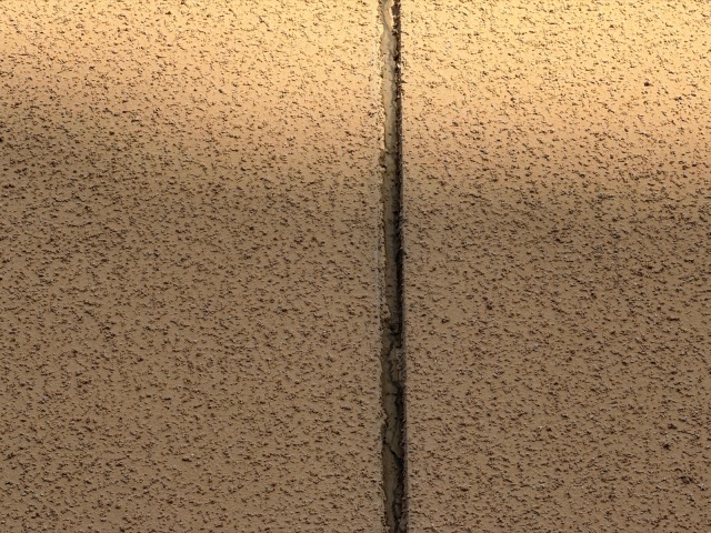 松原市別所のI様邸 モルタル外壁の縦方向の深いクラック(ひび割れ)縁が欠落している状態