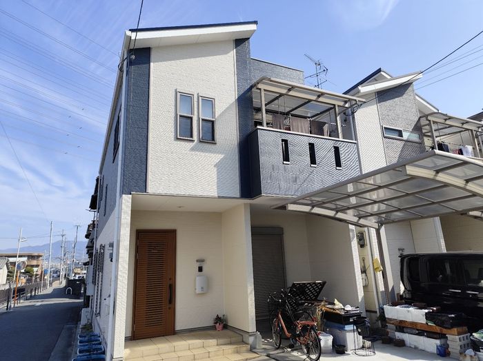 八尾市曙川東 外壁塗装完了後の建物側面・全景（青空に映えるネイビー×ホワイト）