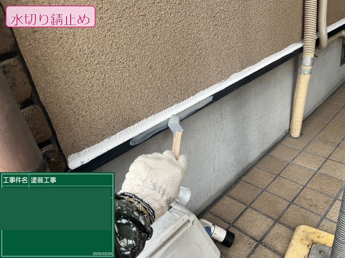 八尾市久宝寺のI様邸 水切り板金の錆止め塗装 刷毛で白い錆止め塗料を塗布している職人の手元