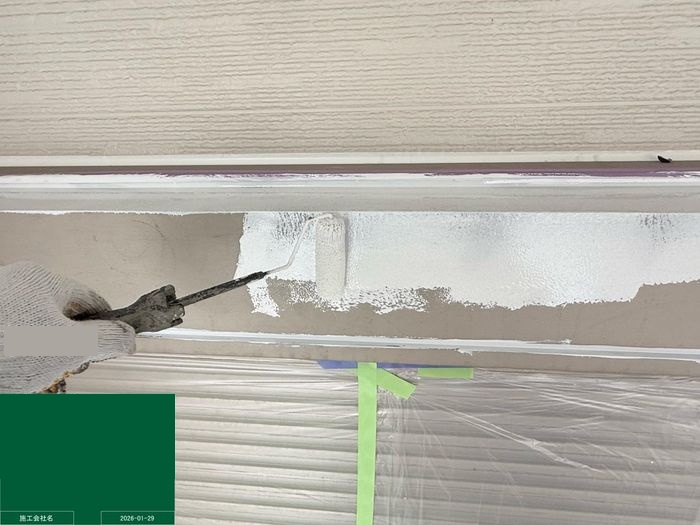 八尾市曙川東のT様邸 シャッターボックスにローラーで白い錆止め塗料を塗布している工程