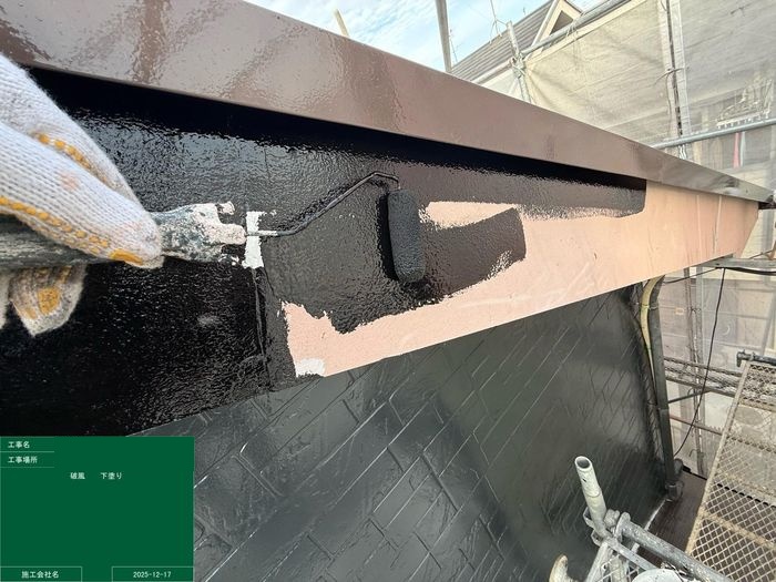 松原市別所 破風板の上塗り施工中・ローラーで黒系塗料を塗布