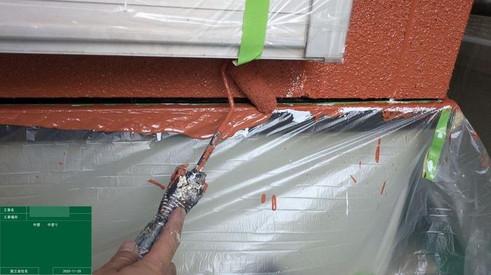 八尾市太子堂のO様邸 ブラウン外壁の中塗り テラコッタ色の塗料を塗り際を塗っている様子