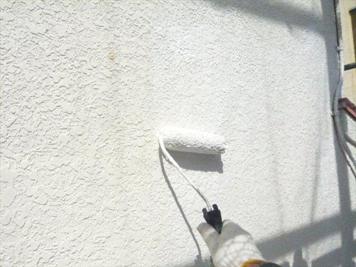 ローラーで外壁塗装中
